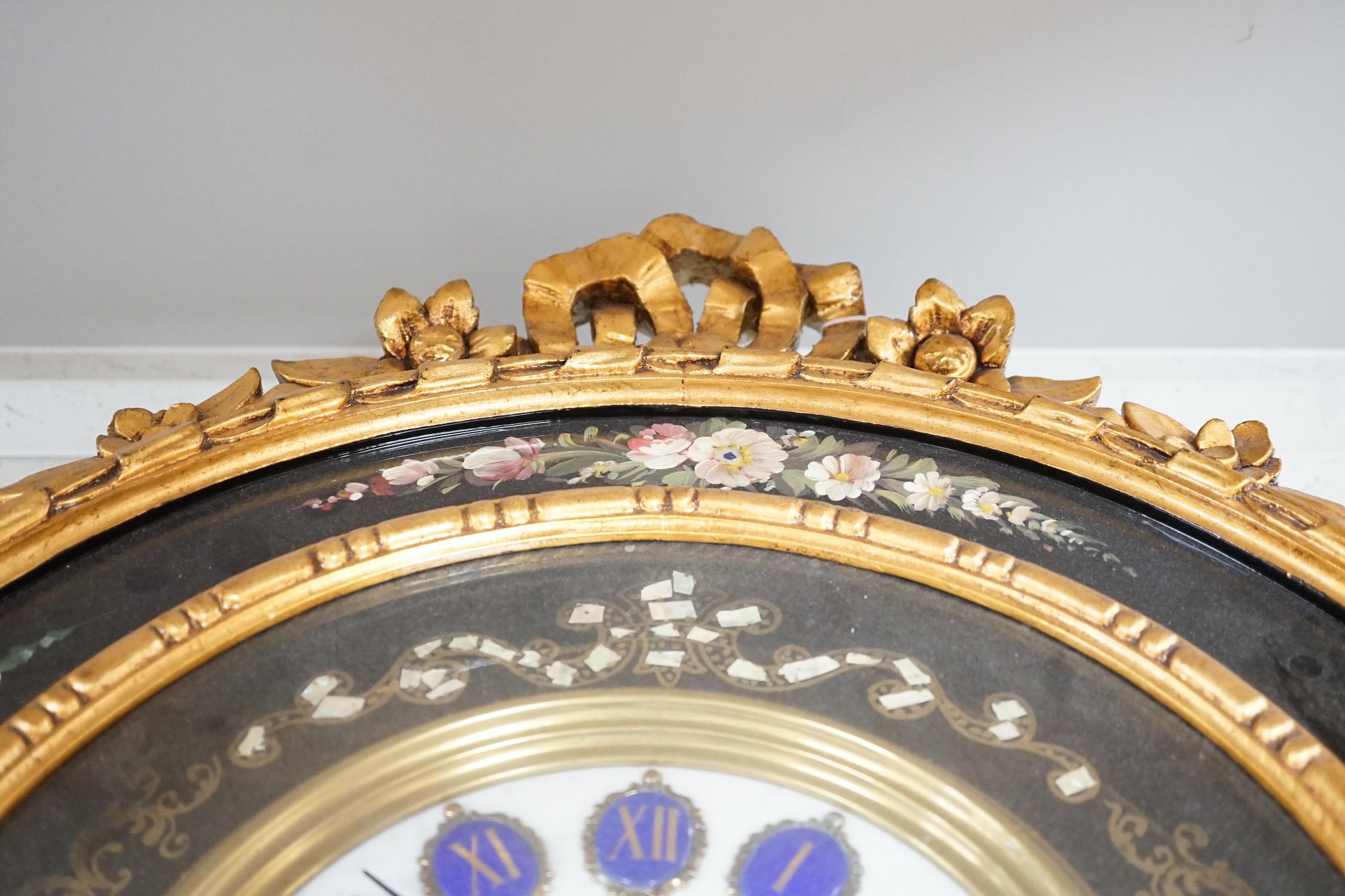 A floral painted clock, length 63cm, quartz movement